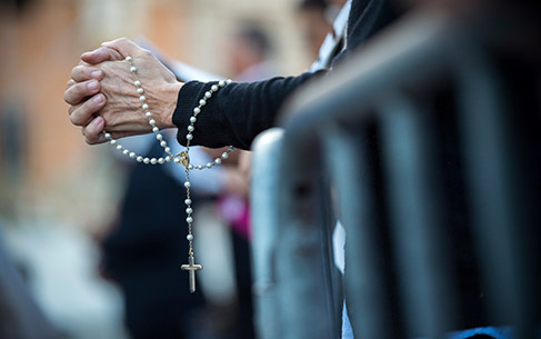 Rome Italy, June 18, 2017 : A Woman prays the rosary before the beginning of the celebration of the Holy Mass prior to the Corpus Domini procession from St. John at the Lateran Basilica to St. Mary Major Basilica to mark the feast of the Body and Blood of Christ, in Rome.